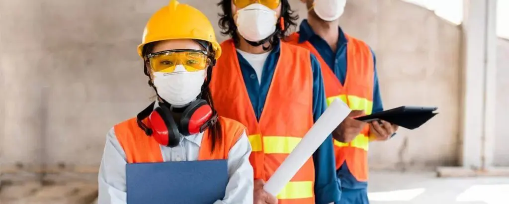 three construction workers looking at the camera wearing face masks